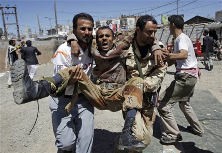 Anti-government protestors carry a wounded defected army soldier from the site of clashes with security forces, in Sanaa, Yemen, on Saturday. Medical officials in Yemen say security forces have fired on protesters in the capital Sanaa, killing several and wounding dozens.